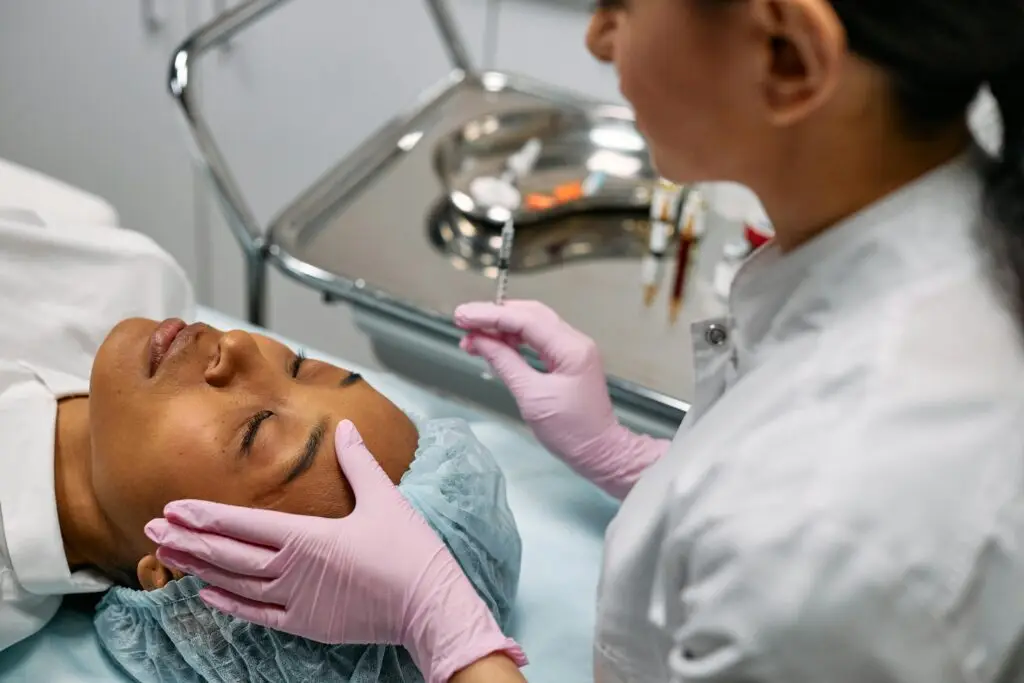 Professional administering skincare treatment with syringe indoors.
